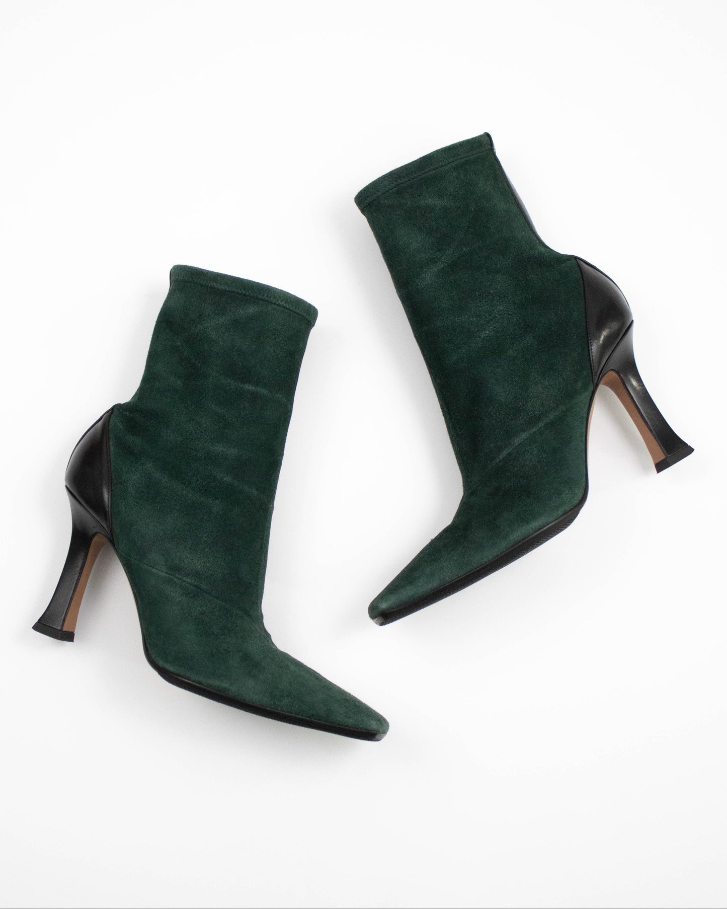 Pair of green suede high-heeled Celine boots on a white background