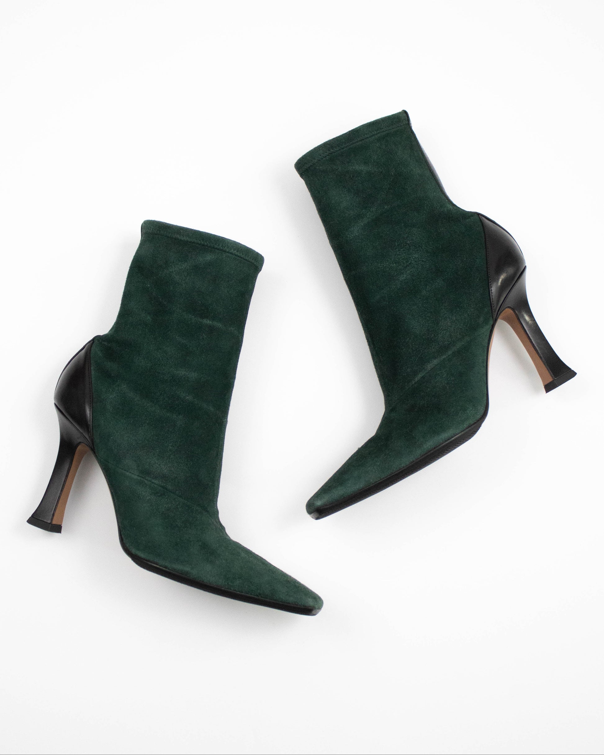 Pair of green suede high-heeled Celine boots on a white background