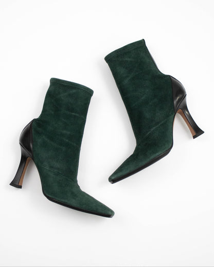 Pair of green suede high-heeled Celine boots on a white background