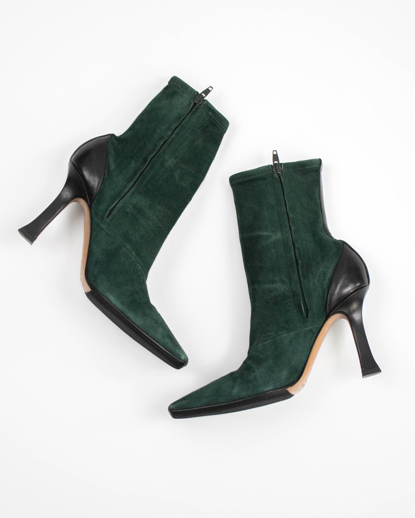 Pair of green suede high-heeled Celine boots on a white background