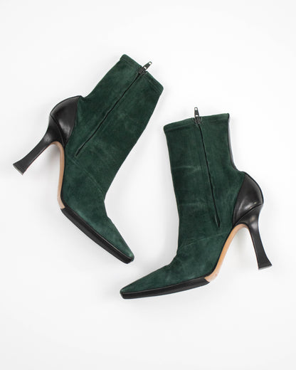 Pair of green suede high-heeled Celine boots on a white background