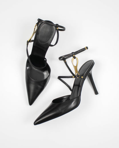 Black high-heeled Gucci shoes with gold horsebit accents side view 