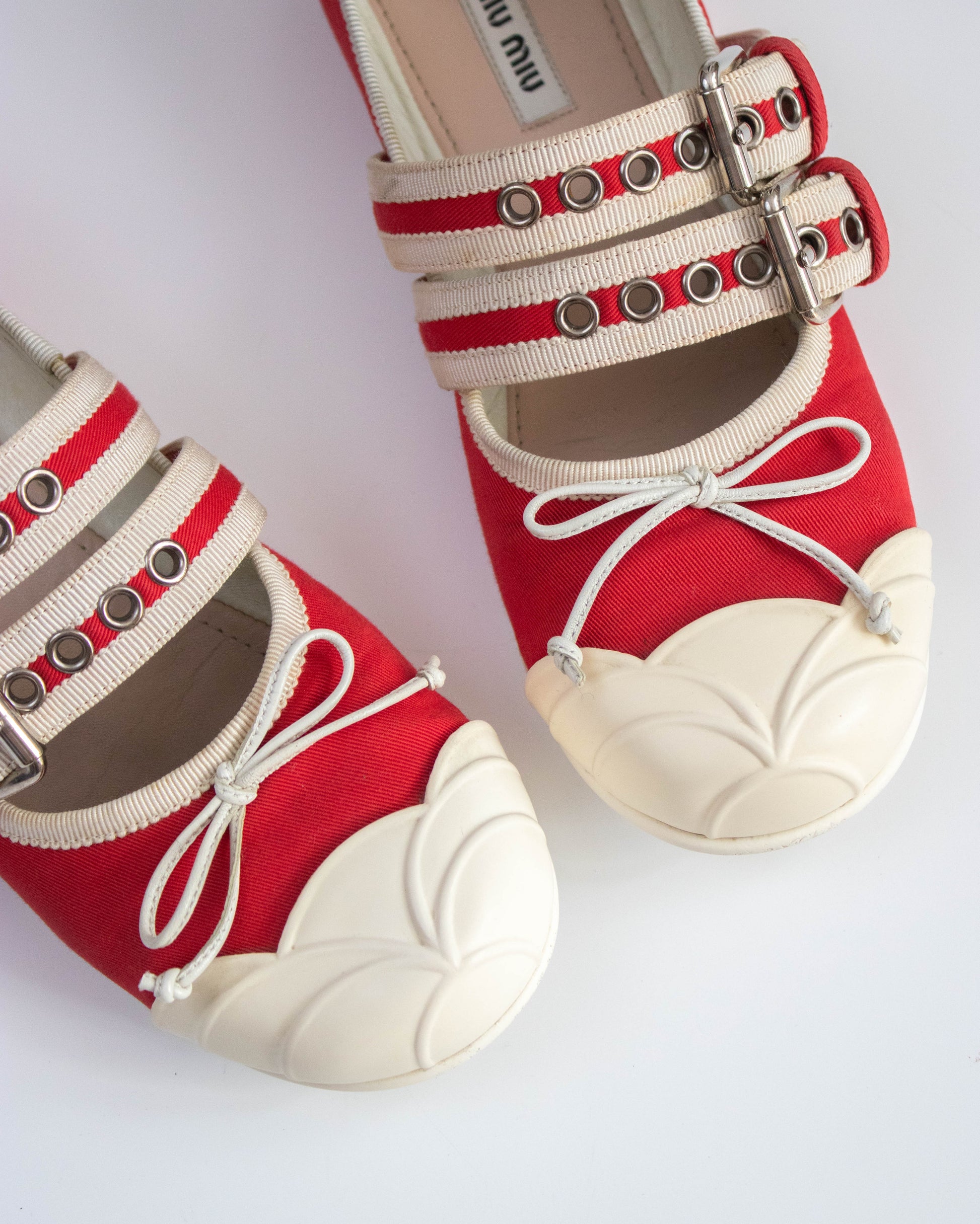Red shoes with white soles and decorative straps on a white background