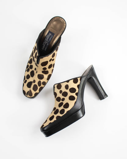 Pair of dalmatian print mules on a white background top view