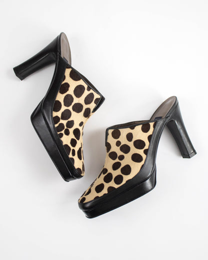 Pair of dalmatian print mules on a white background side view