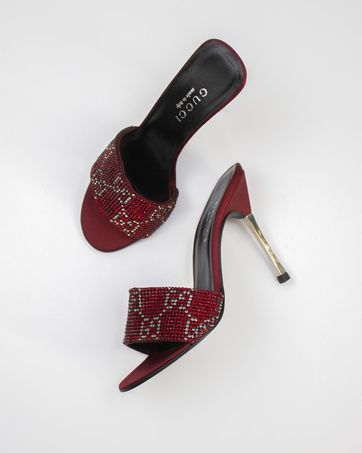 Red high-heeled shoes with beaded design on a white background