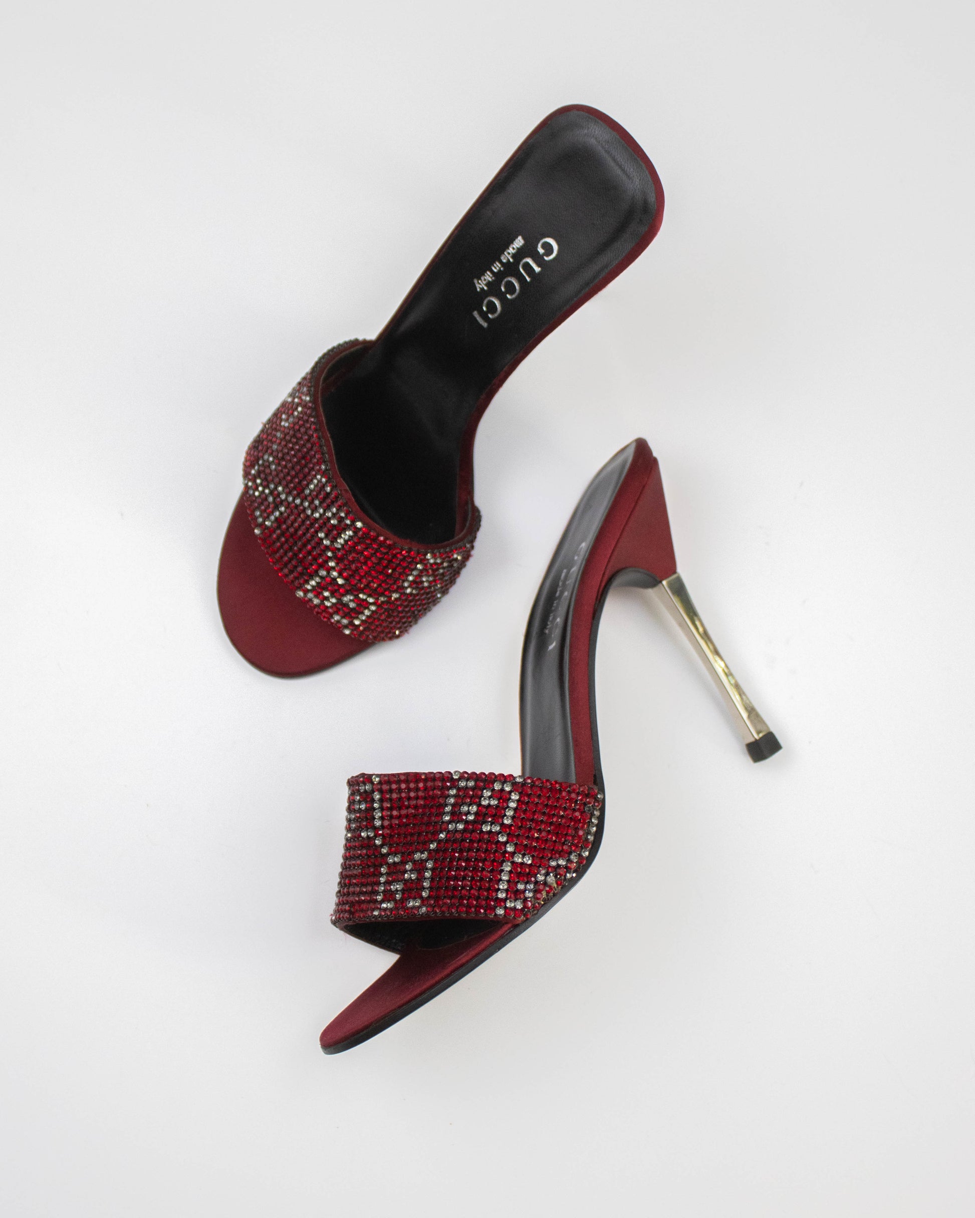 Red high-heeled shoes with beaded design on a white background