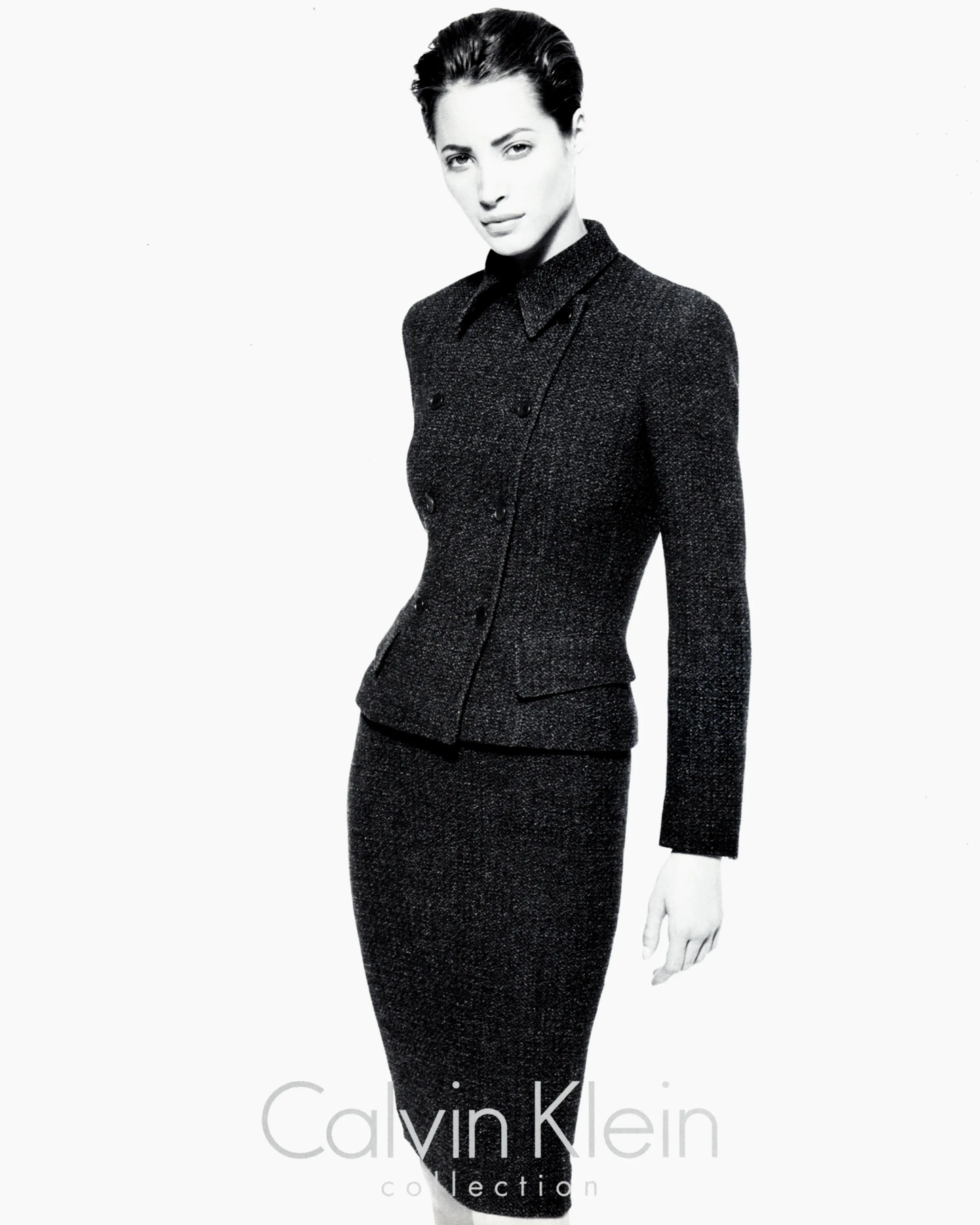Black and white image of a woman wearing a Calvin Klein suit on a white background