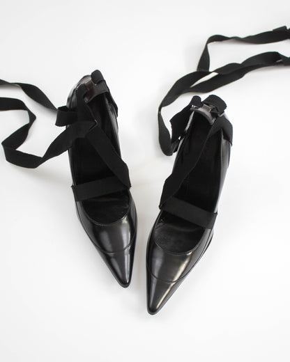 Pair of black pointed-toe Gucci heels with straps top view