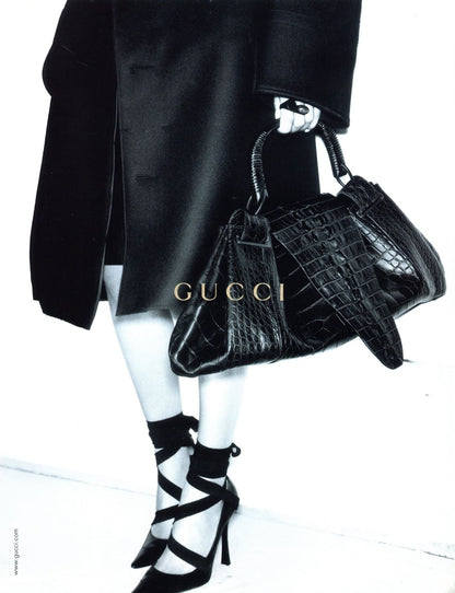 Pair of black pointed-toe Gucci heels with straps campaign photo