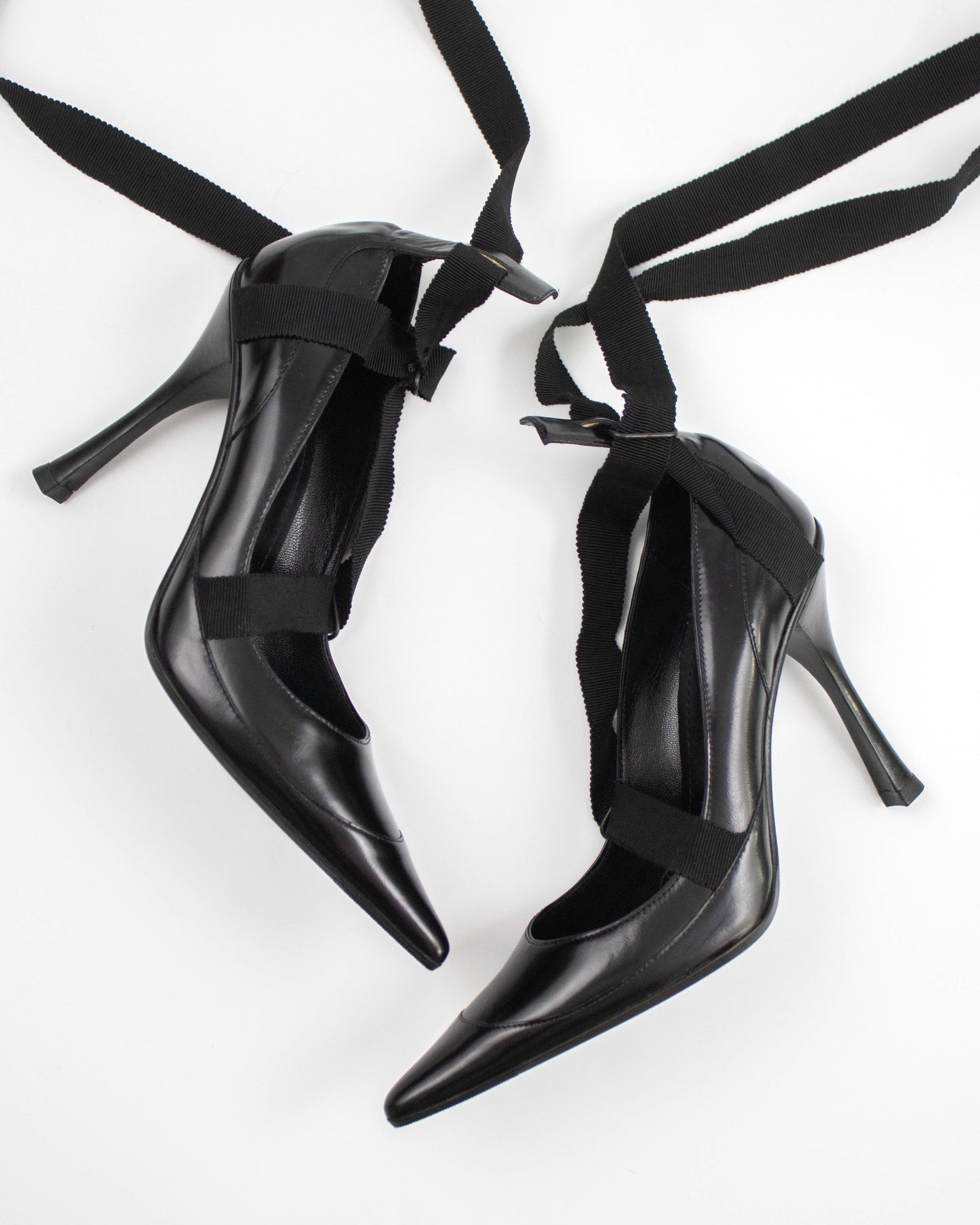 Pair of black pointed-toe Gucci heels with straps side view