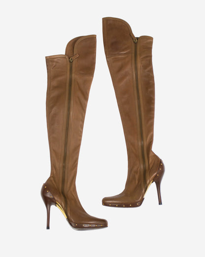 A pair of brown leather over-the-knee boots with side zippers, studded details, and high stiletto heels, shown from the side and front angles against a light gray background.