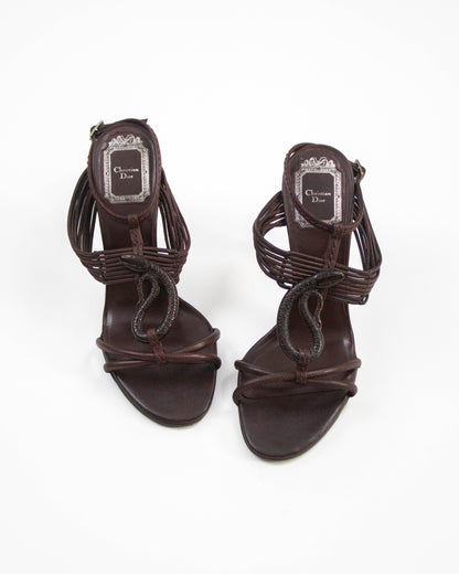 Pair of brown high-heeled sandals with 'Christian Dior' logo on a white background