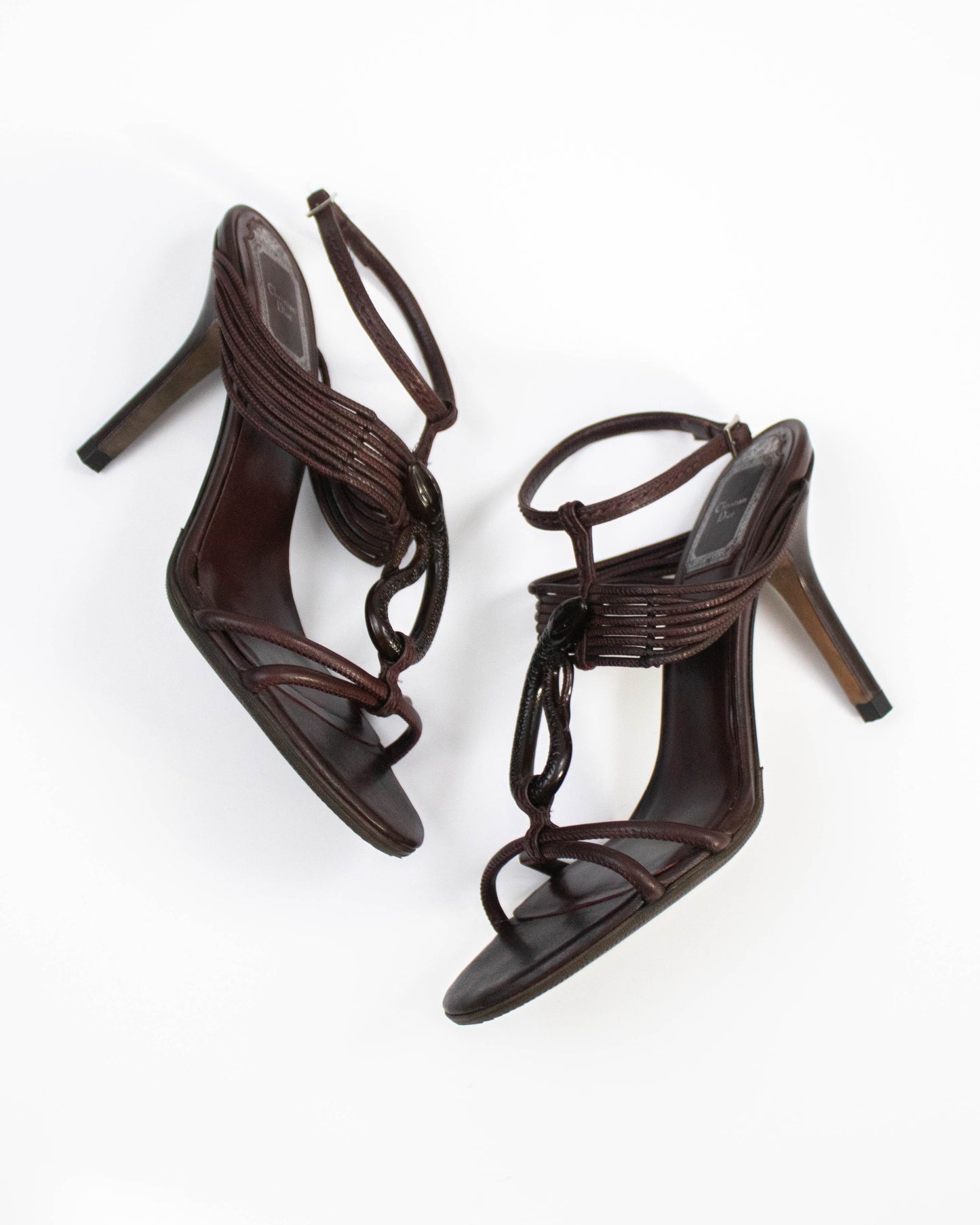 Pair of brown high-heeled Christian Dior sandals on a white background