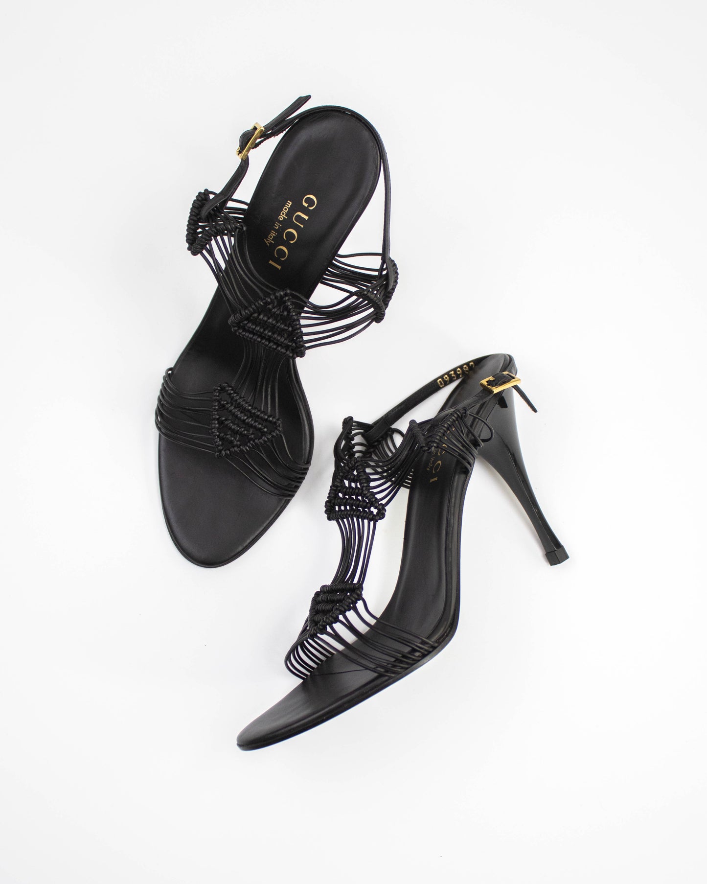 Black high-heeled Gucci sandals with intricate designs side view