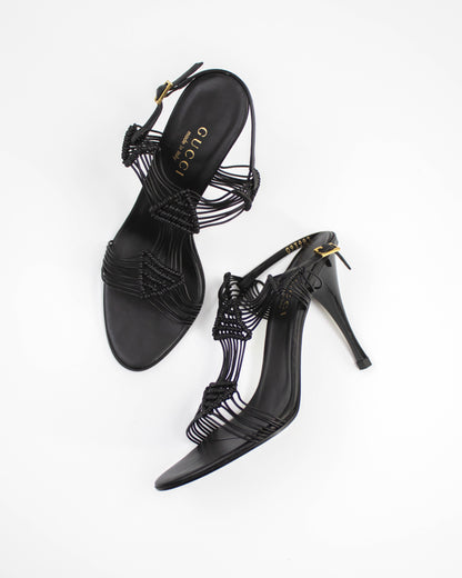 Black high-heeled Gucci sandals with intricate designs side view