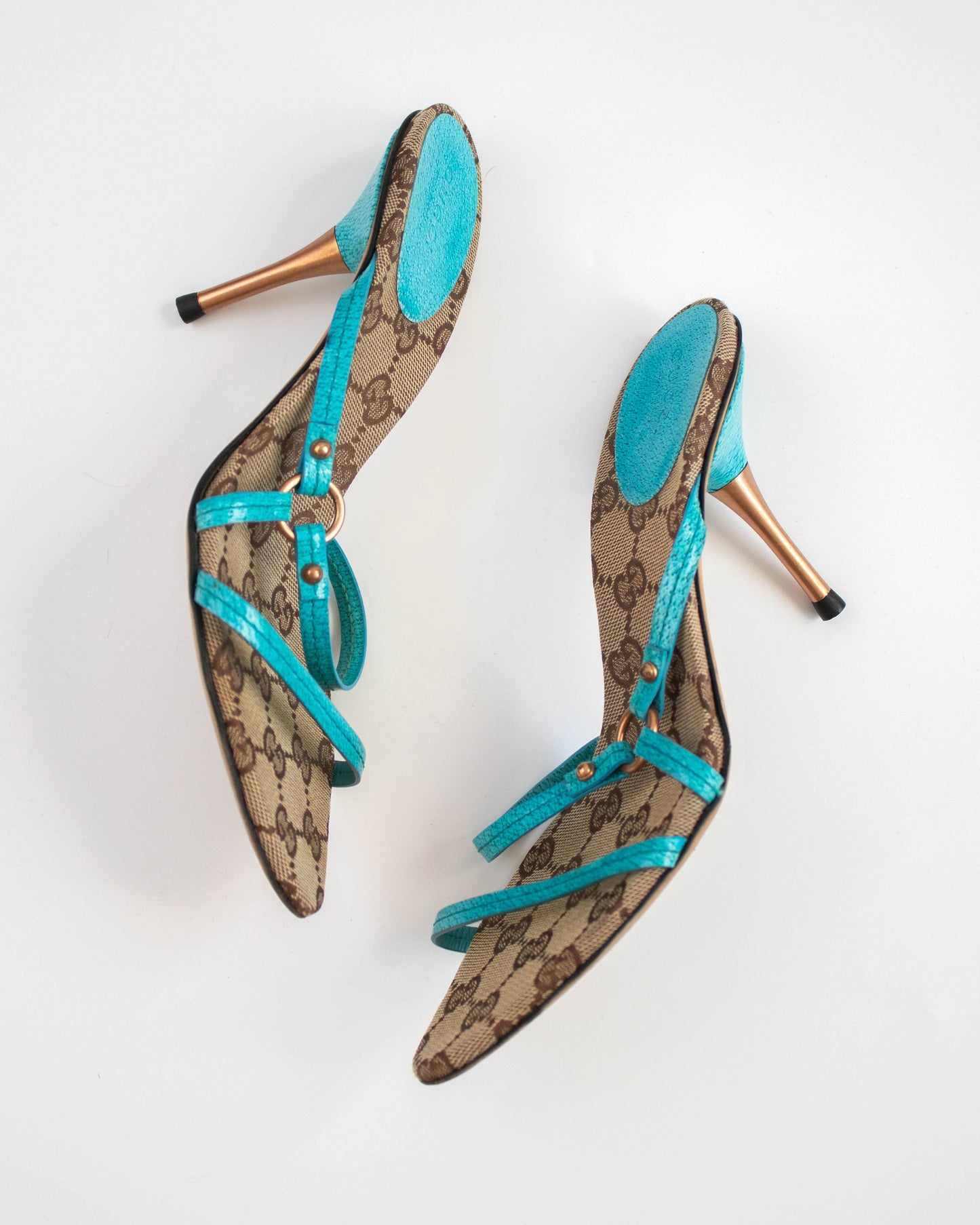 Pair of high-heeled Gucci shoes with turquoise straps side view
