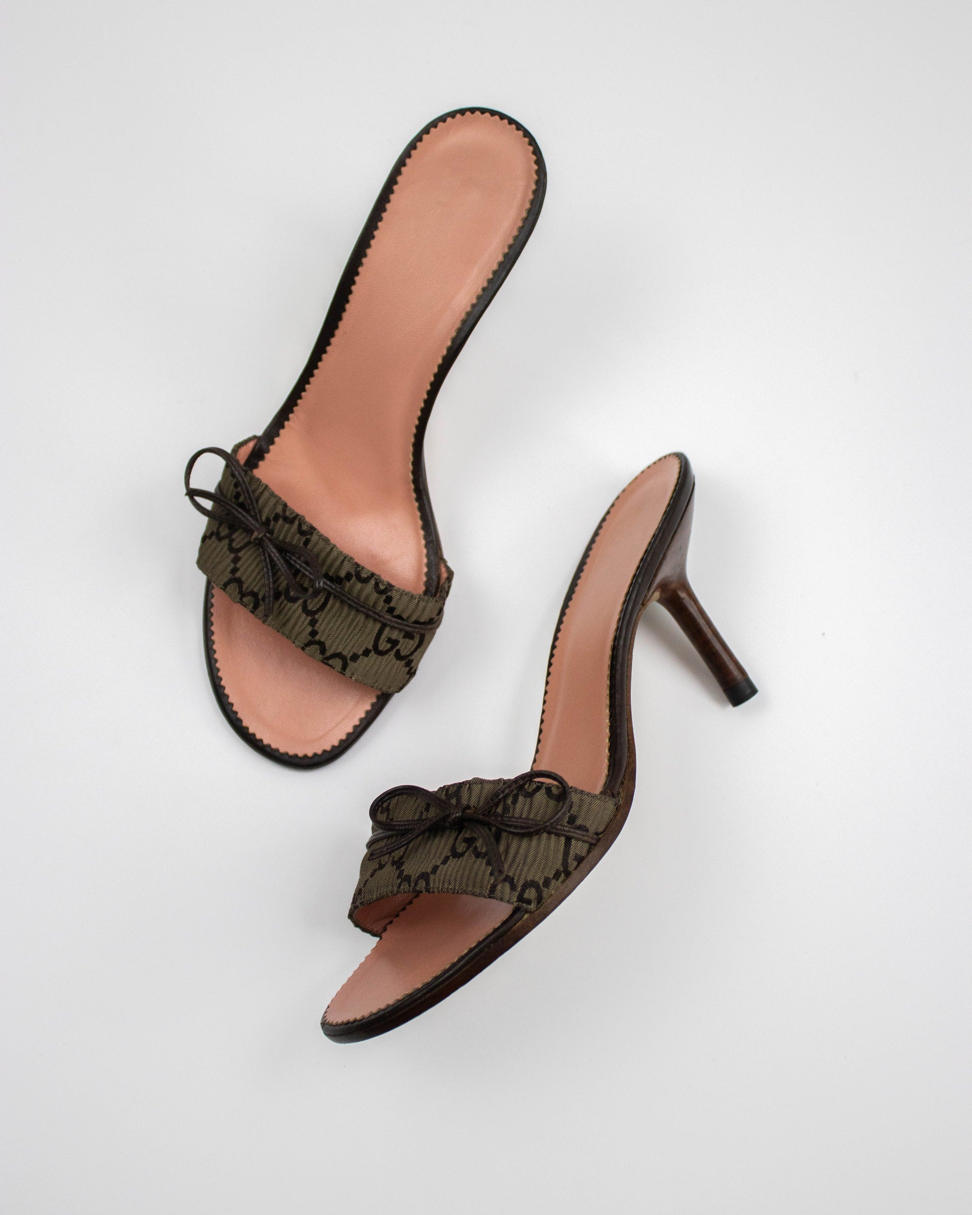 Pair of Gucci brown monogram mules  with bow detail side view