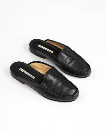 Pair of black leather loafers on a white background