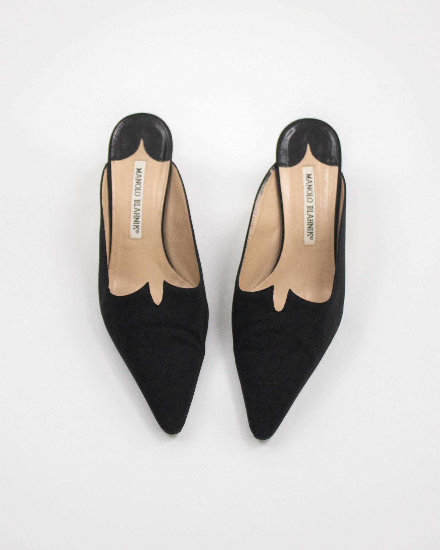 Black low-heeled Manolo Blahnik satin shoes on a white background front view