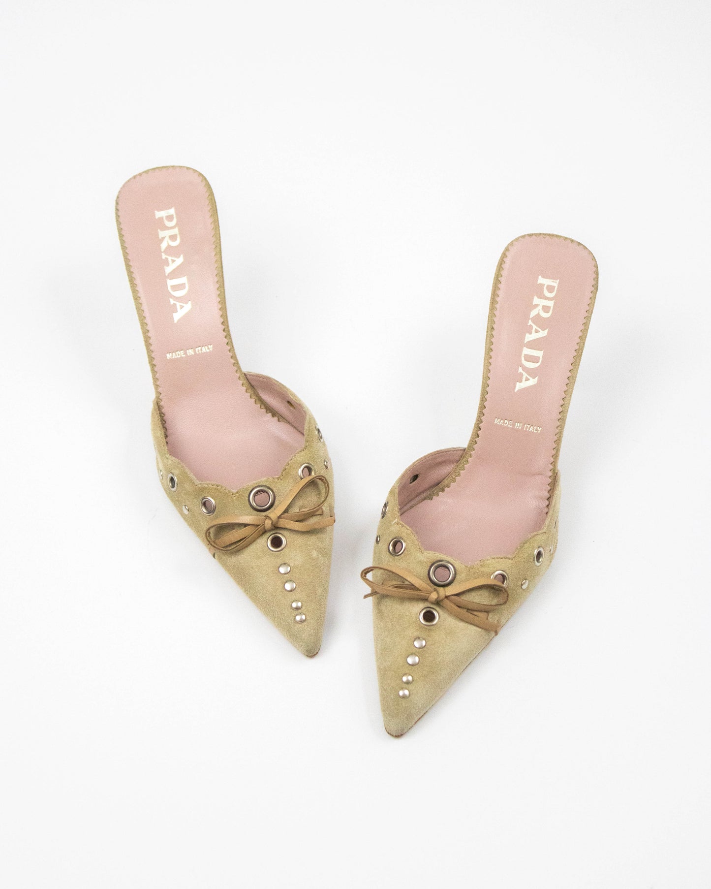 Pair of beige Prada shoes with bow details on a white background
