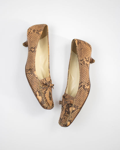 Pair of brown snake print Prada heels on a white background