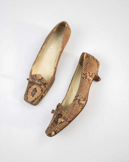Pair of brown snake print Prada heels on a white background