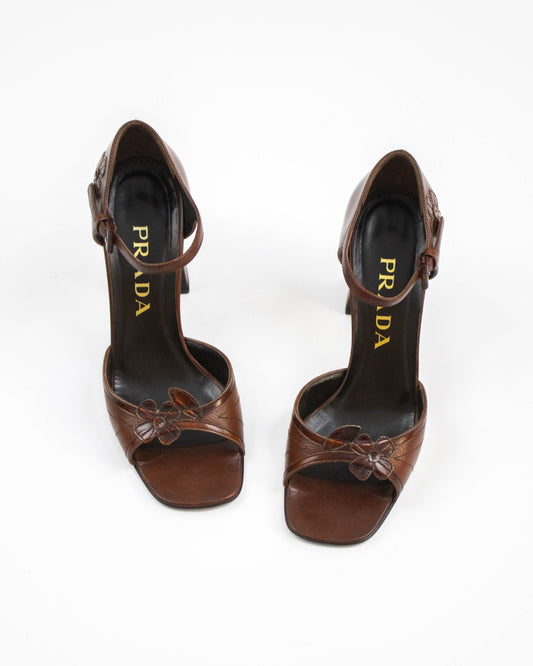 Pair of brown Prada high-heeled shoes with floral applique front view