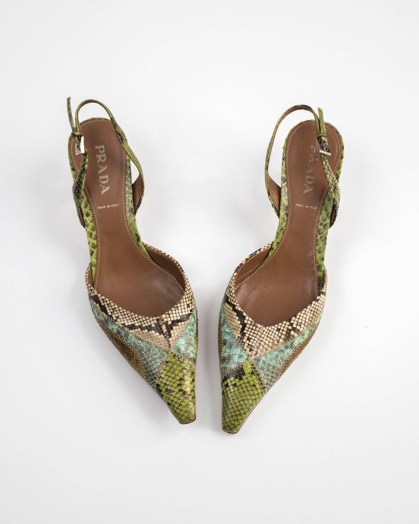 Pair of Prada snake print shoes on a white background top view