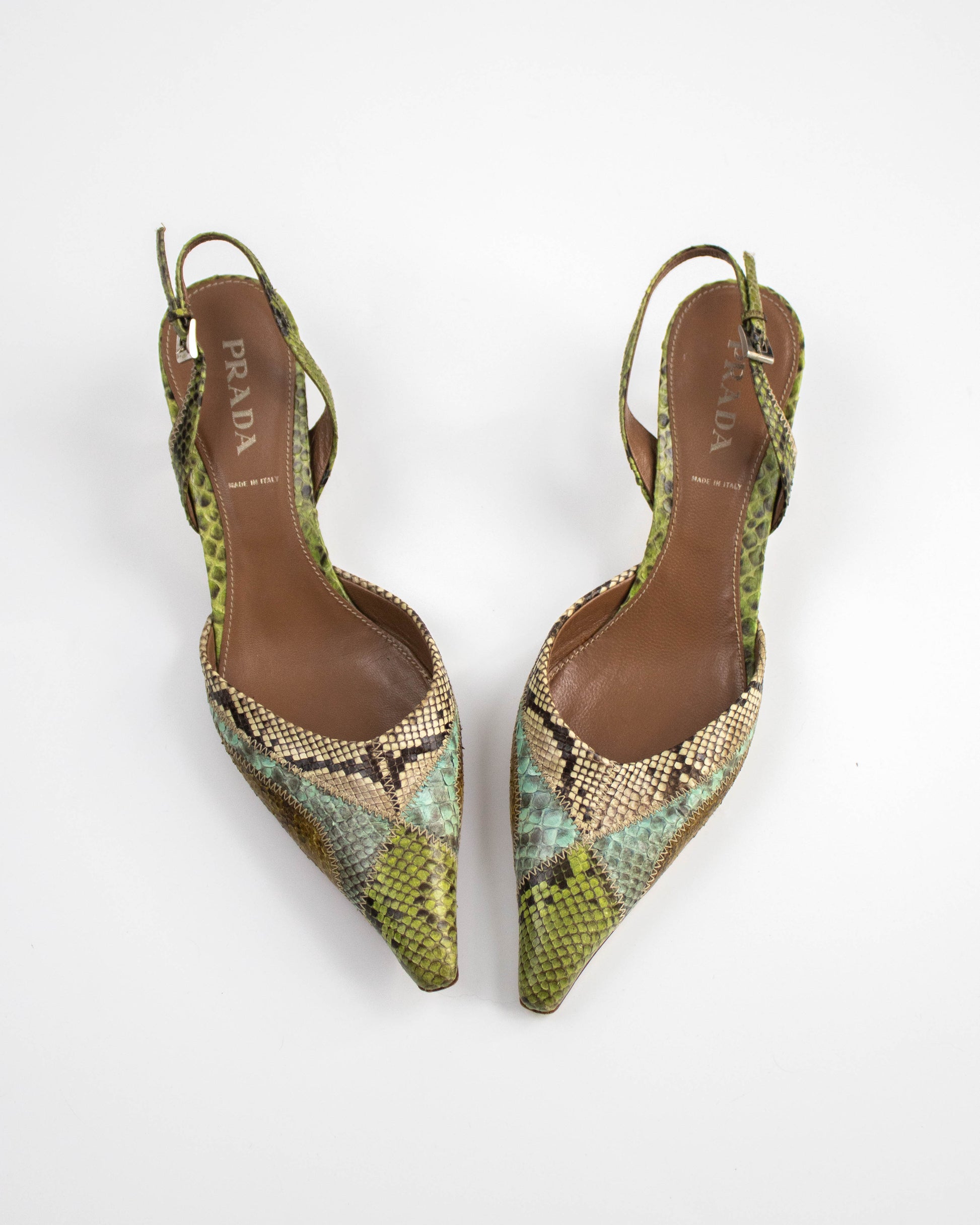 Pair of Prada snake print shoes on a white background top view