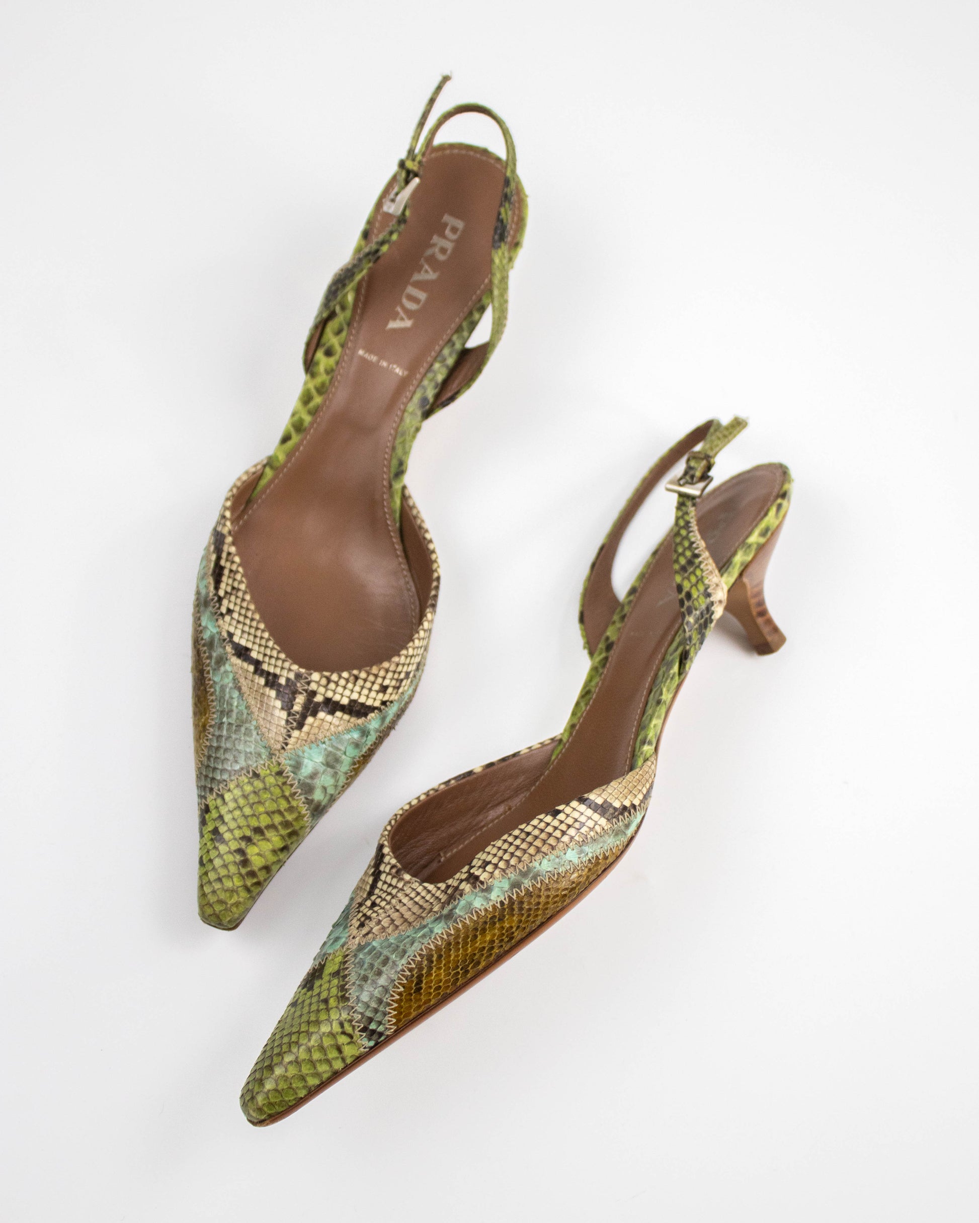 Pair of Prada snake print shoes on a white background side view