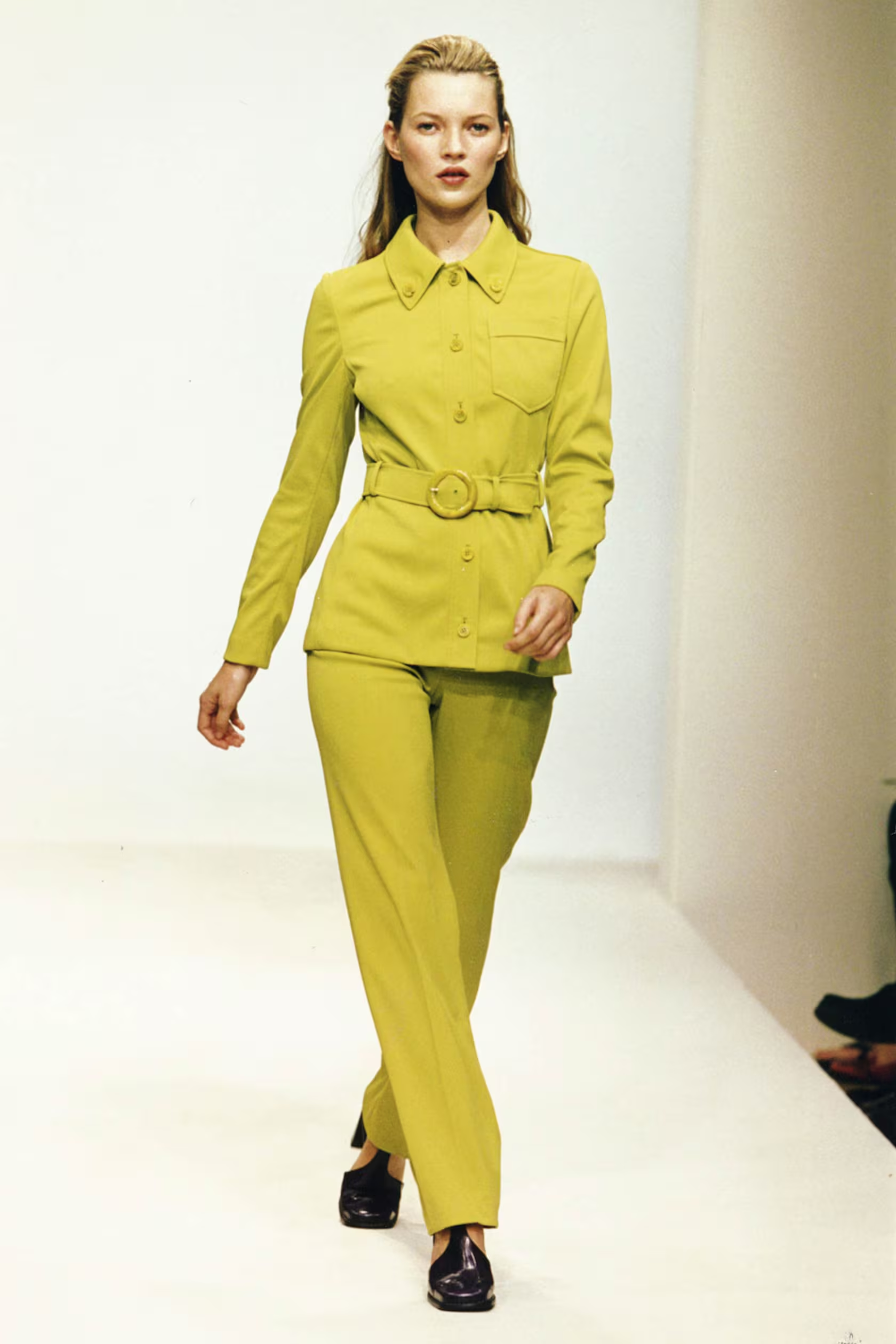 Model wearing a bright yellow outfit on a runway