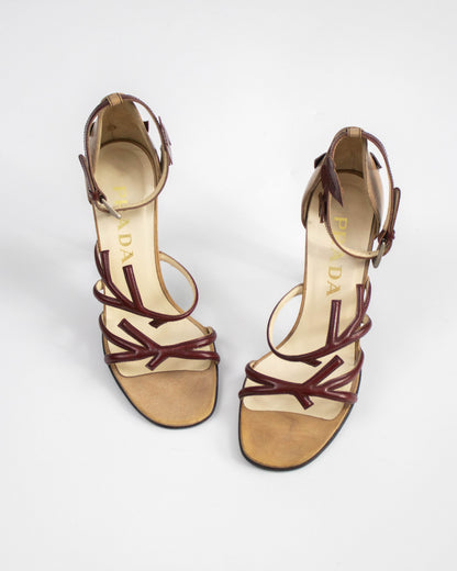 Pair of high-heeled sandals with brown straps on a white background