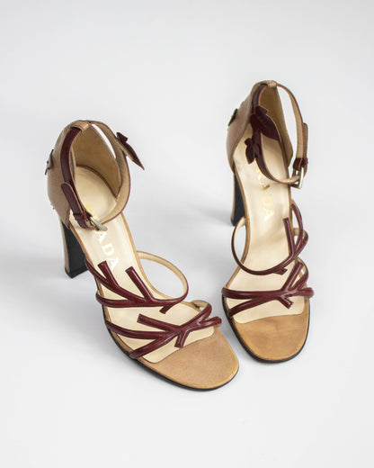 Pair of high-heeled sandals with brown straps on a white background