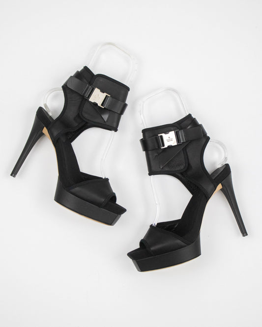 Black high-heeled shoes with buckles on a white background