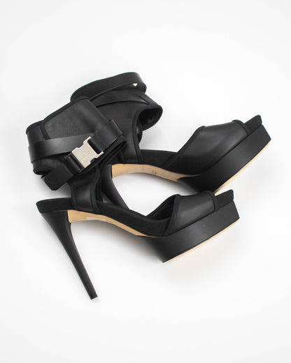 Black high-heeled sandals with a buckle on a white background